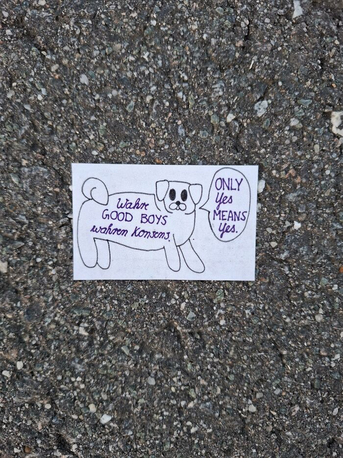 A hand-drawn dog on a piece of found paper placed on asphalt with a speech bubble saying ONLY Yes MEANS Yes.