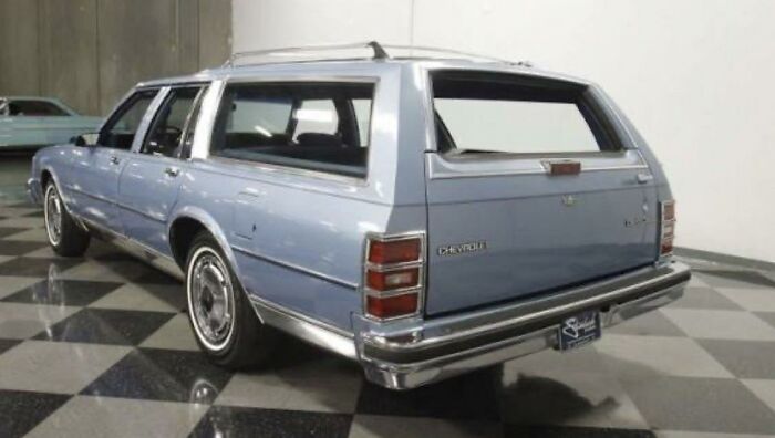 Vintage blue Chevrolet station wagon parked inside, captured in nostalgic photos for 80s kids childhoods.