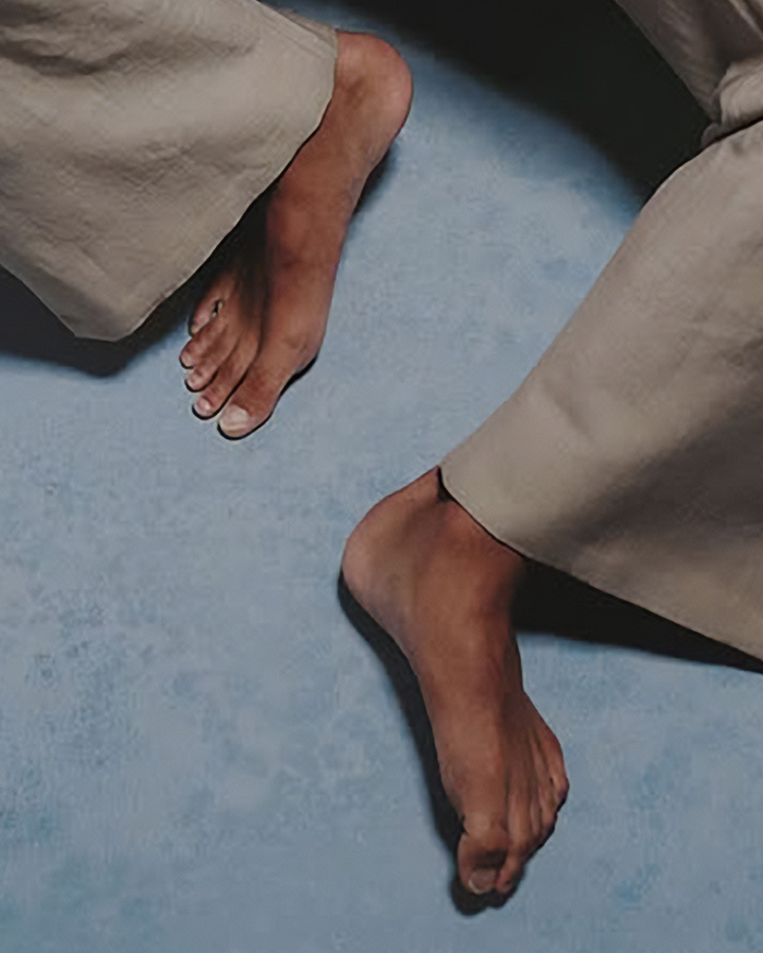 Close up of bare feet during a photoshoot showing grooming habits on a blue background