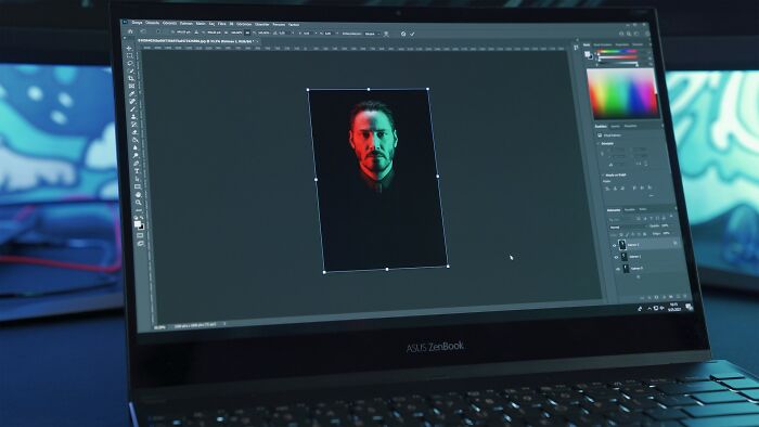 A laptop screen displaying a photo editing software, contrasting Hollywood movie hacking with reality.