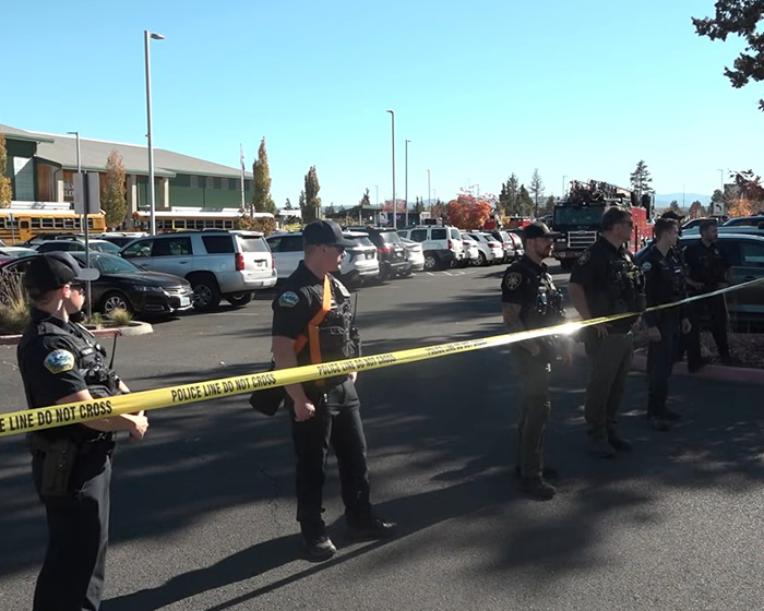 Police officers securing parking lot with yellow tape at Oregon elementary school Police officers securing parking lot with yellow tape at Oregon elementary school