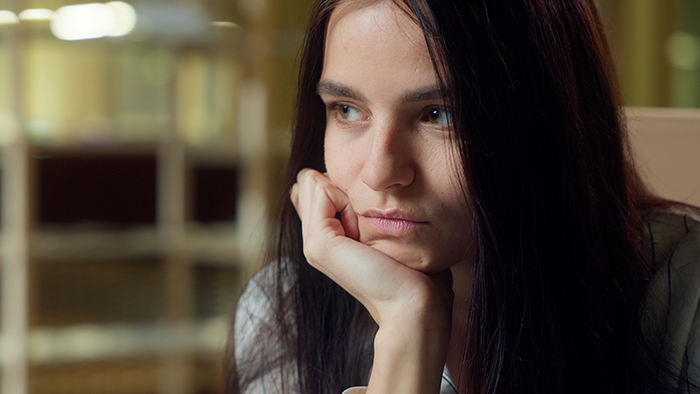 A thoughtful-looking woman resting her chin on her hand, contemplating setting a clear boundary. A thoughtful-looking woman resting her chin on her hand, contemplating setting a clear boundary.