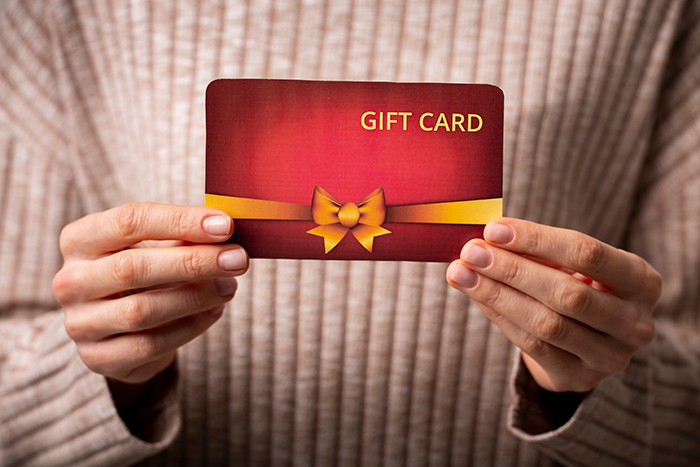 A woman holding a red gift card, symbolizing family support A woman holding a red gift card, symbolizing family support
