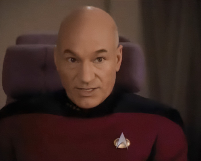 Patrick Stewart in character as Captain Jean-Luc Picard wearing a Star Trek uniform.