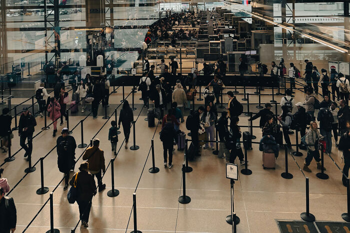Busy airport terminal with travelers standing in long security lines illustrating petty revenge stories