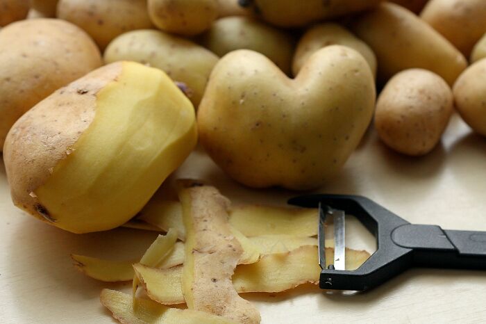 Freshly peeled potatoes beside a peeler, representing hurtful comments from narcissistic parents.