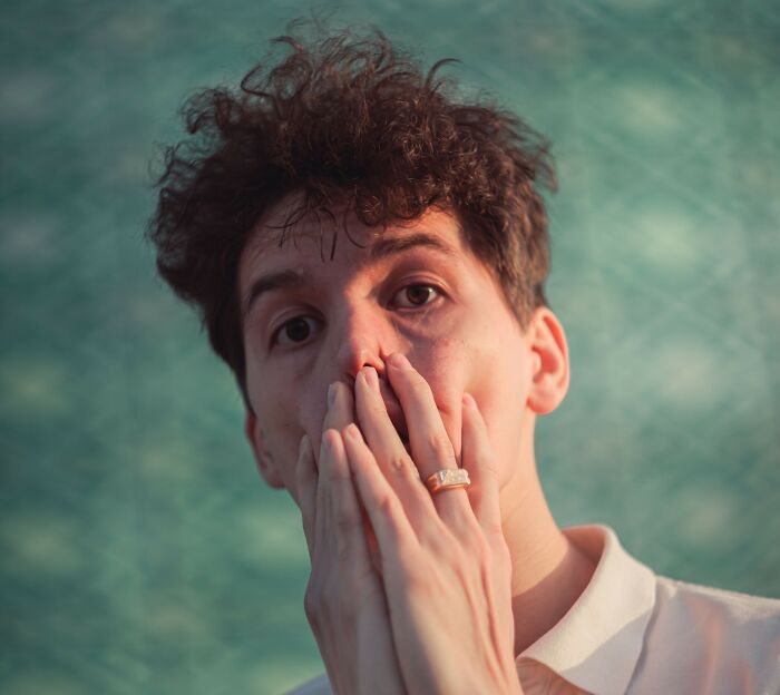 Person covering mouth in surprise, representing microaggressions awareness