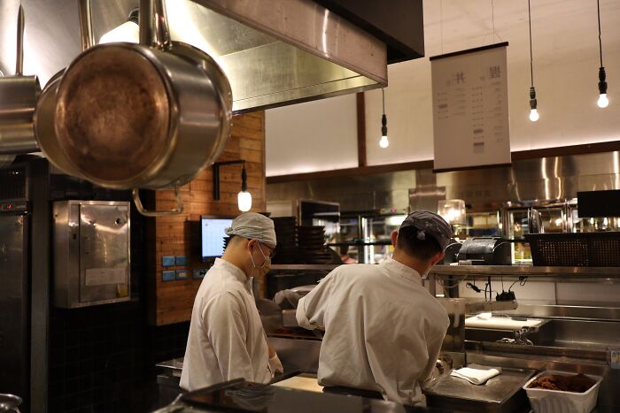 Chefs working in a busy commercial kitchen, giving a behind the scenes look at restaurant operations