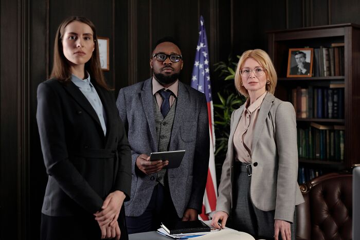 Diverse business team standing in office with serious expressions on microaggressions