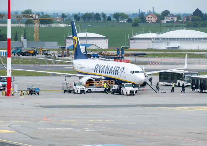 Ryanair airplane parked at tarmac near airport gate, illustrating a flight gate change scenario.
