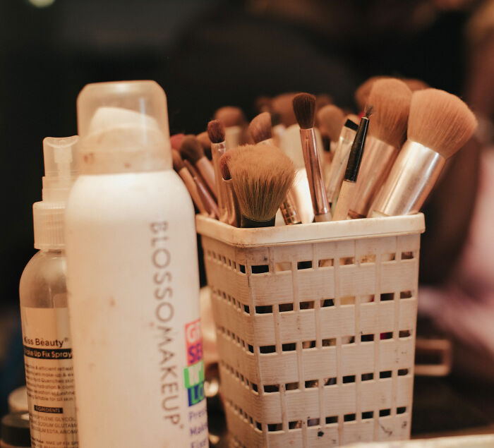 Various makeup brushes in a holder, representing hygiene issues behind the scenes in fashion.