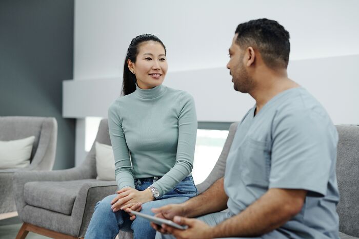 A medical professional speaking with a client in a modern office, building professional trust