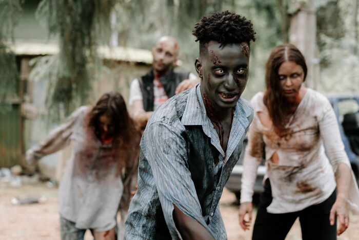 Spooky zombies walking outdoors, depicting Hollywood horror movie tropes.