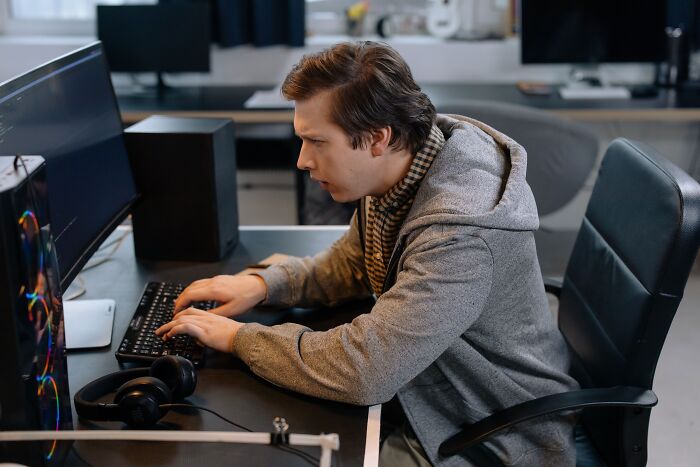 Software developer working at a computer desk, representing industry insiders behind the scenes in tech