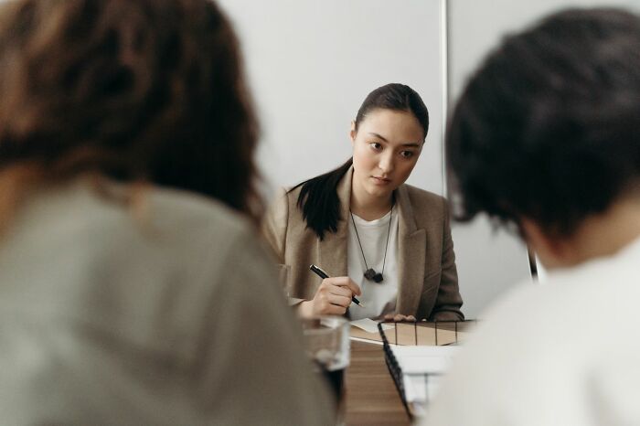 A focused professional listening in a meeting, using clever life tricks for better office communication