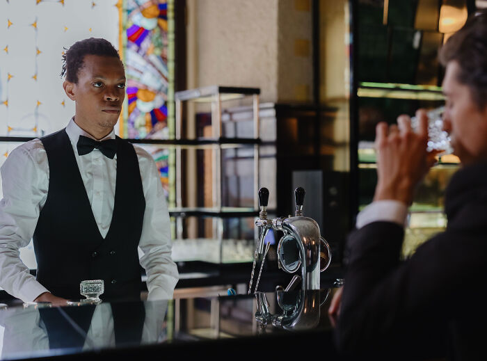 Male bartender serving drinks, contrasting with an unruly Karen couple at a restaurant. Male bartender serving drinks, contrasting with an unruly Karen couple at a restaurant.