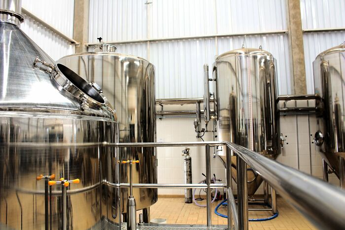 Large stainless steel brewing tanks, illustrating companies people refuse to give another dollar to.