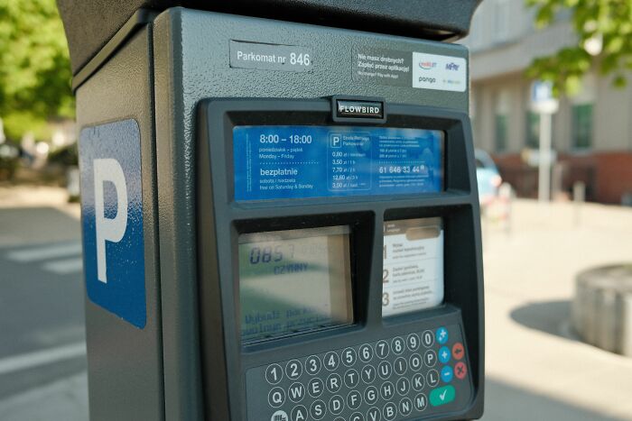 A parking meter machine on the street, illustrating unethical life pro tips about parking fees