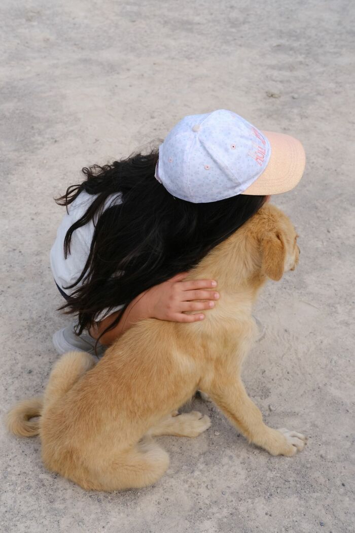 A girl hugging a puppy outdoors, capturing funny instances when folks failed or made silly mistakes.