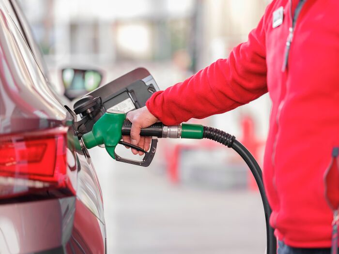 Close-up of a fuel nozzle refilling a car, highlighting dumb things professionals said or did while working