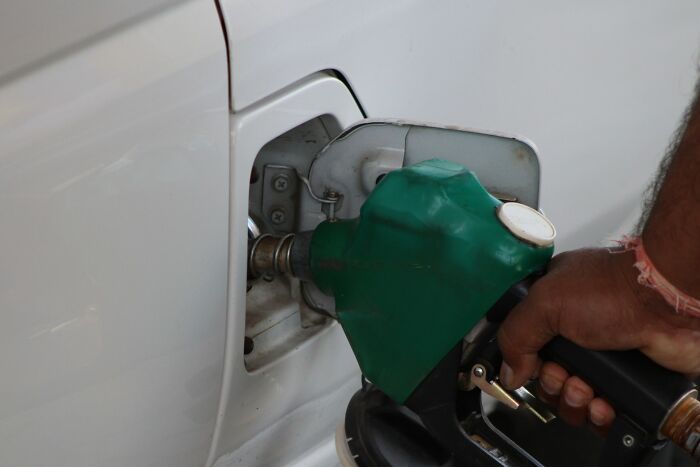 Hand fueling a white vehicle representing unhinged things people did to get back at their ex