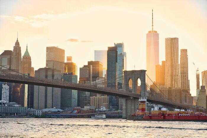 The Brooklyn Bridge and New York City skyline at sunset, showing a typical movie setting to highlight Hollywood tropes.