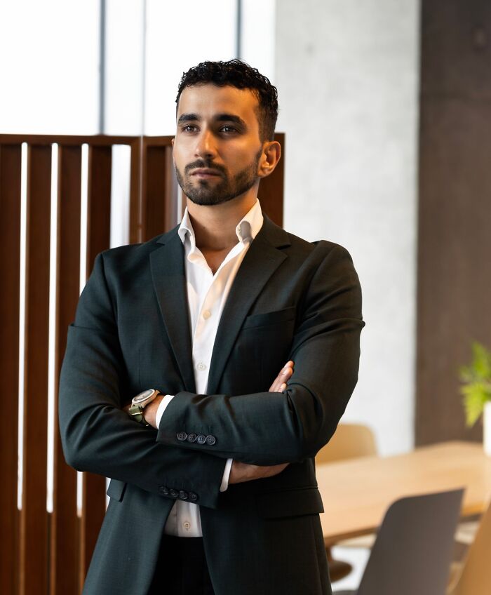 A man in a suit posing thoughtfully, illustrative of satisfying revenge stories.