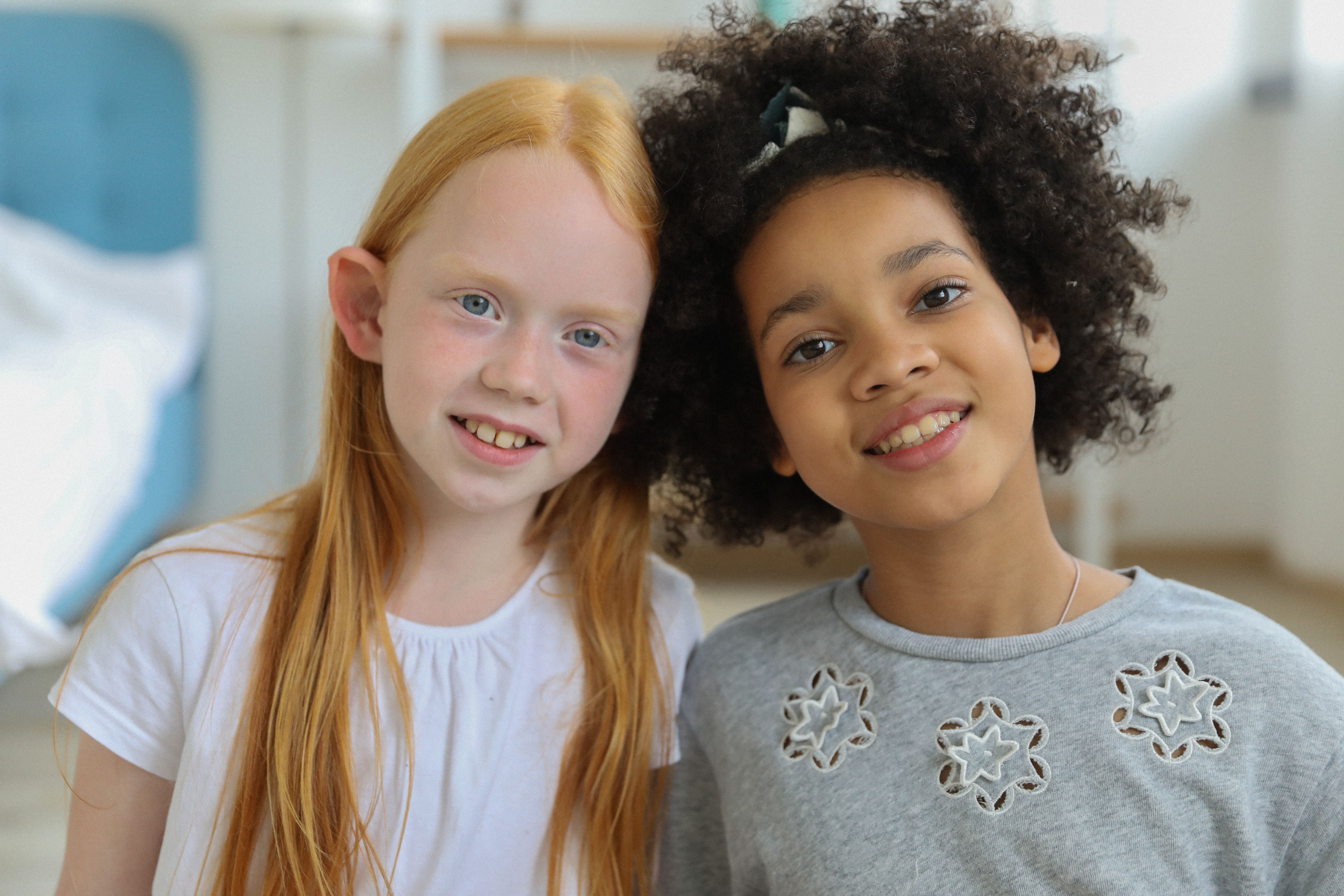Two happy young girl friends smiling together, representing a close friendship. Two happy young girl friends smiling together, representing a close friendship.