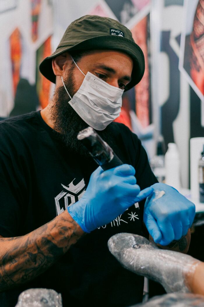 A tattoo artist working carefully to avoid funny instances of embarrassing fails