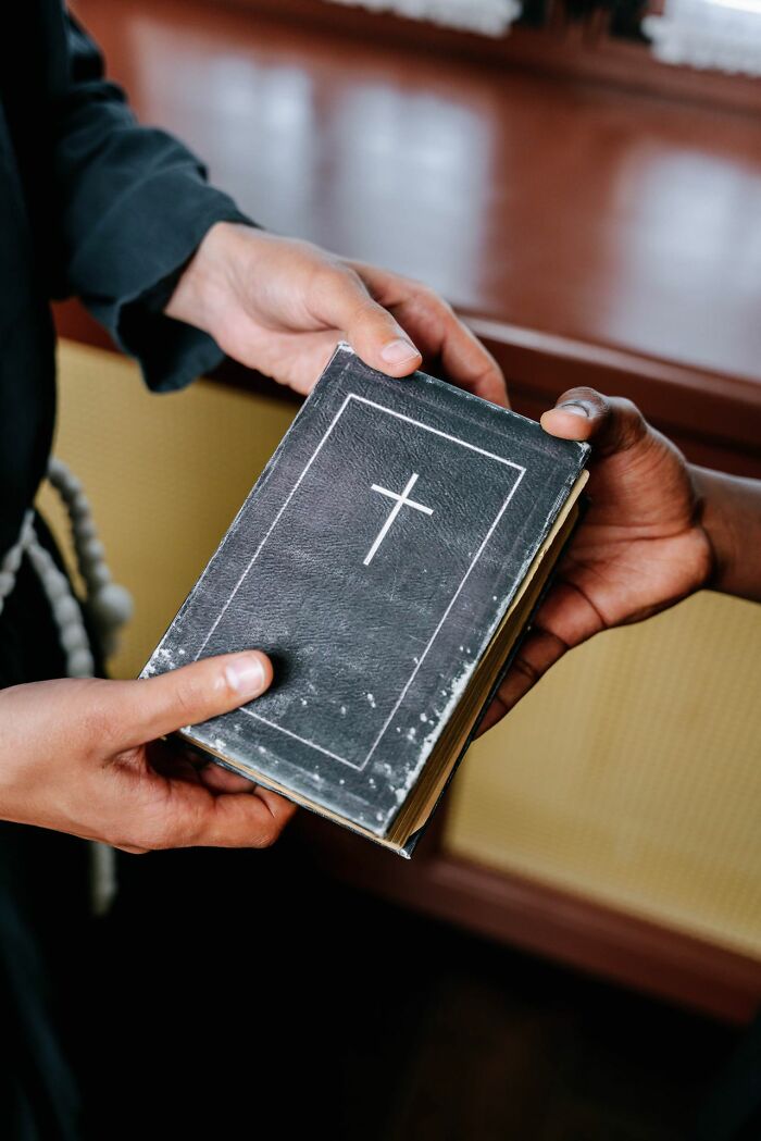 Two people holding a small Bible received during trick-or-treating