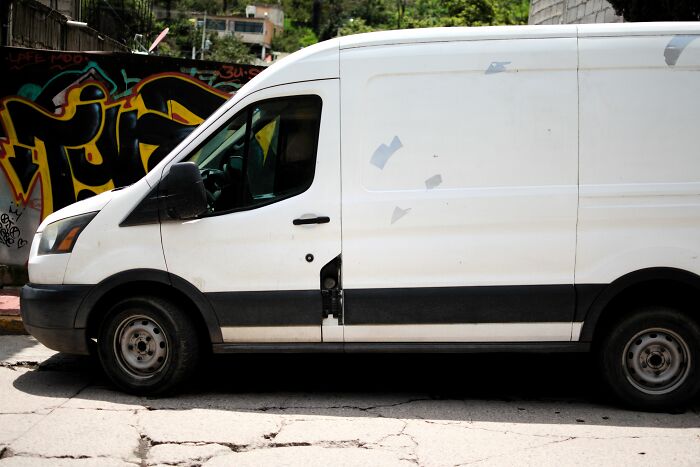 A plain white cargo van parked by a wall, illustrating chilling stories of gut feeling.