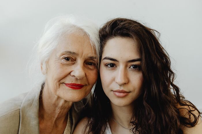 An older woman with grey hair alongside a younger woman, sharing wisdom women wish they knew.