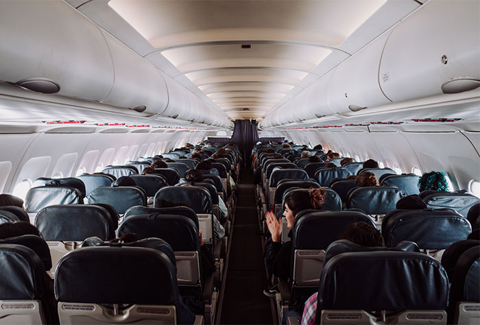 Interior view of a crowded airplane cabin mid-flight where a dad was caught red handed