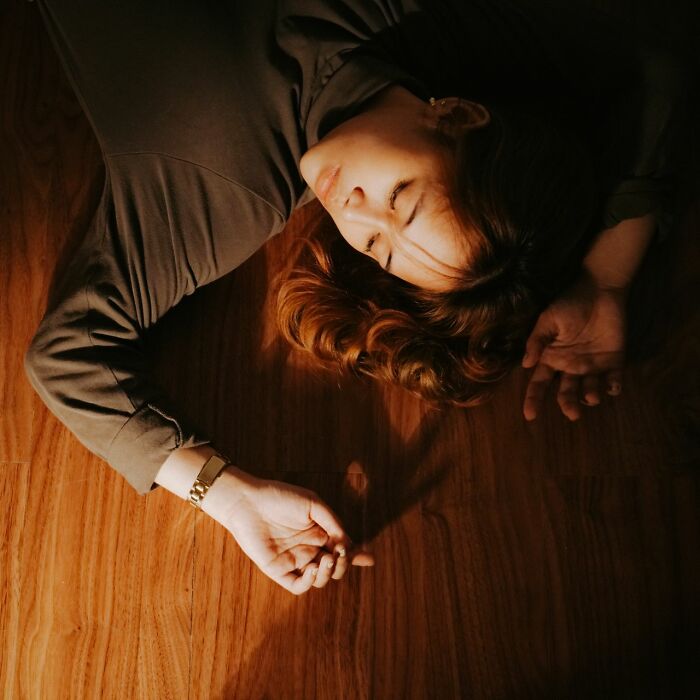 Woman lying on floor looking overwhelmed after Karen encounter