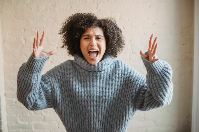 Woman expressing frustration about Karens in grey sweater