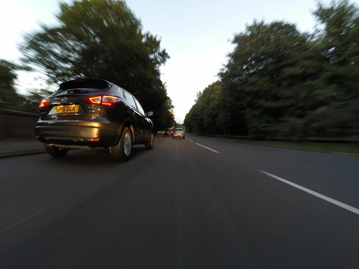 A car driving fast down a road, symbolizing a sudden need to leave immediately