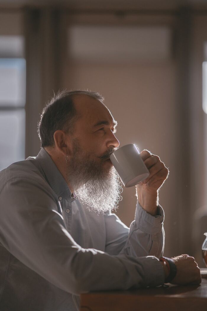 Bearded man drinking coffee at table illustrating adult reflection in Karen stories