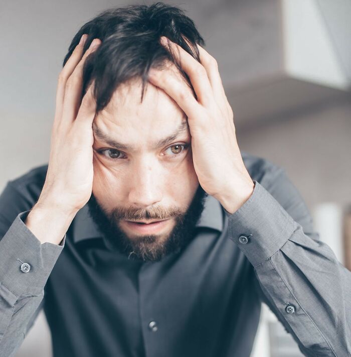 Anxious man holding his head in distress, illustrating the emotional toll when men walk away from marriage