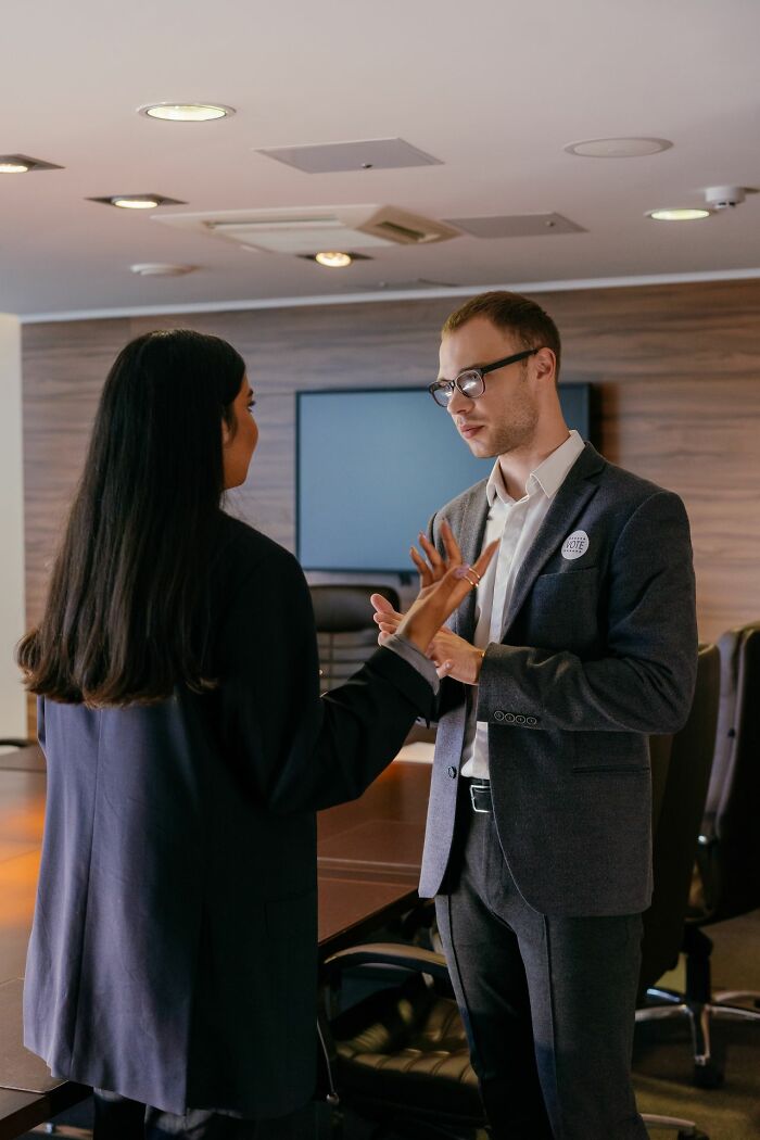 Two professionals discussing clever life tricks in a modern office meeting room