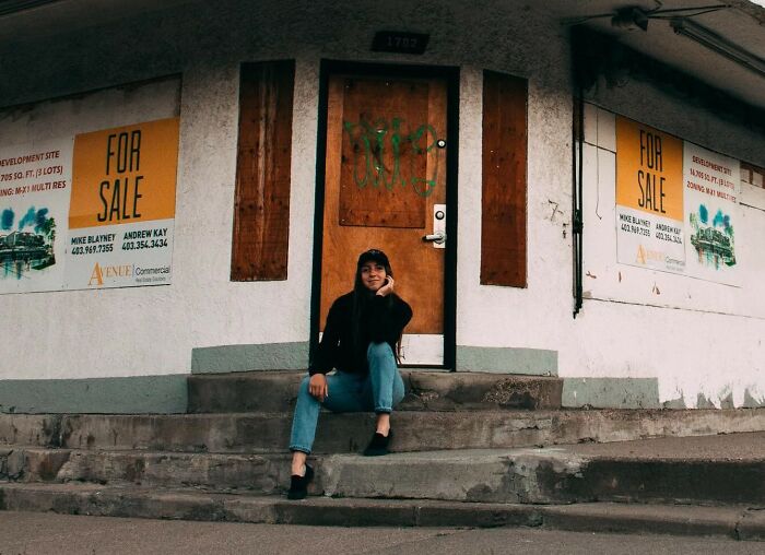 Woman sitting on steps of an abandoned building related to chilling stories