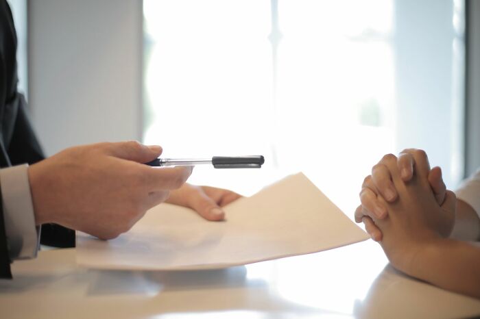 Person holding a pen over a document during a meeting showcasing clever life tricks for success