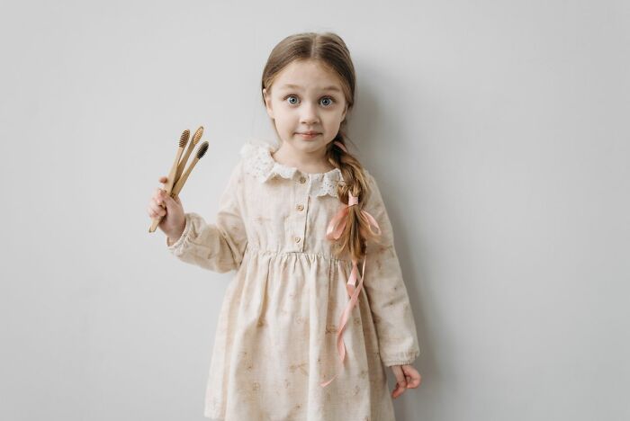 A young girl holding wooden toothbrushes received during trick-or-treating