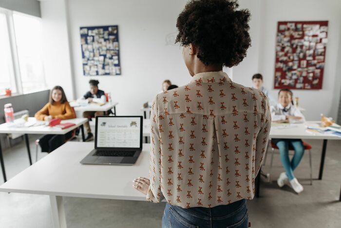 Teacher standing in classroom with students teaching microaggressions women hear