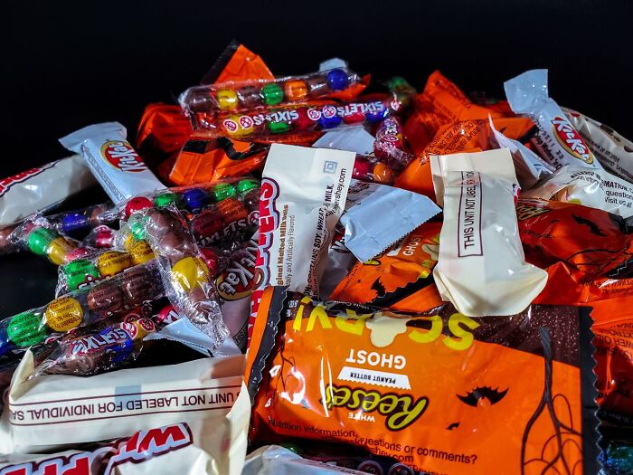 A large pile of various colorful Halloween candy representing Halloween conflicts over trick-or-treating.