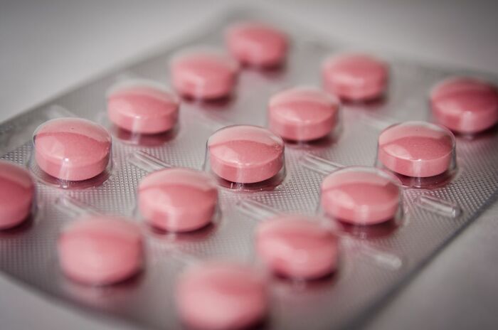 A blister pack of pink pills representing health-related clever life tricks and medicine management