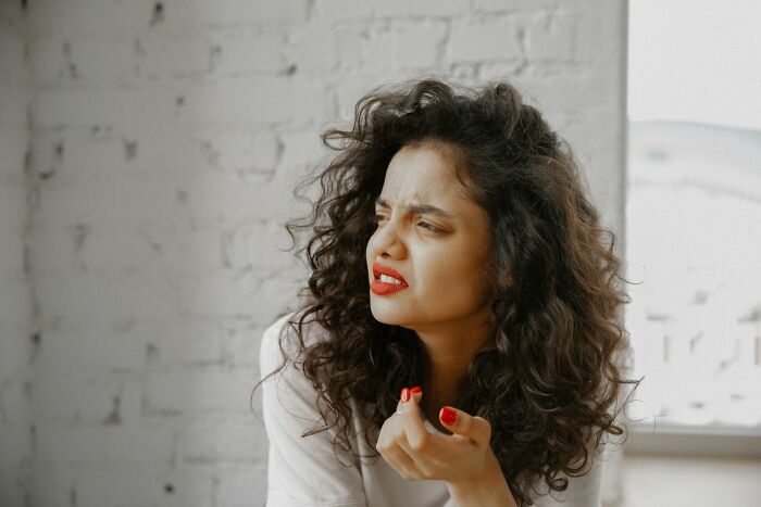 A frustrated woman with curly hair expressing disappointment about why men walk away from their marriage.