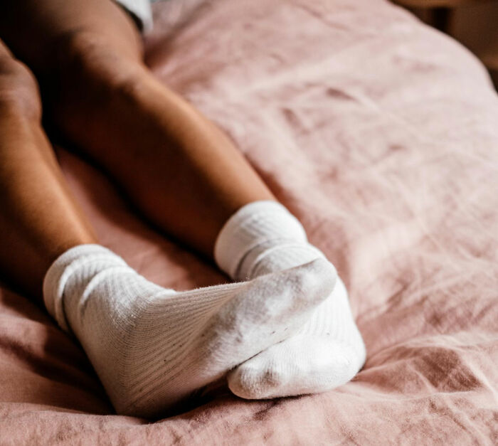 Person wearing white socks resting on bed practical life hacks