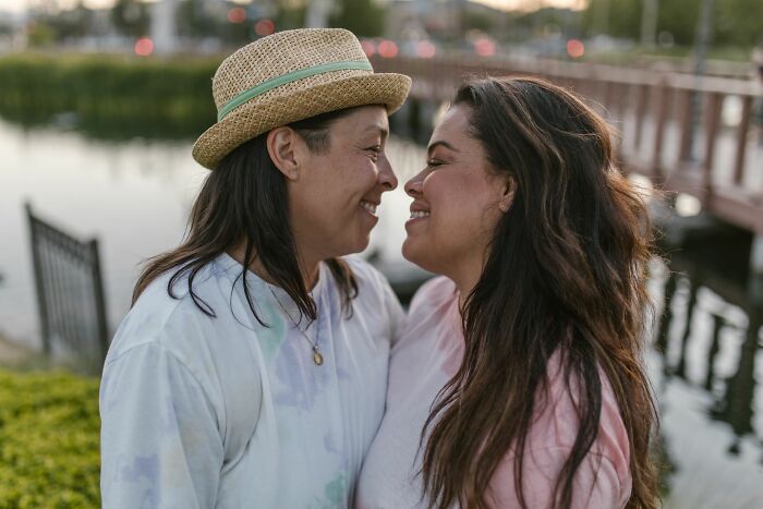 Two smiling women looking at each other, depicting a strong bond that survives any walked away marriage.