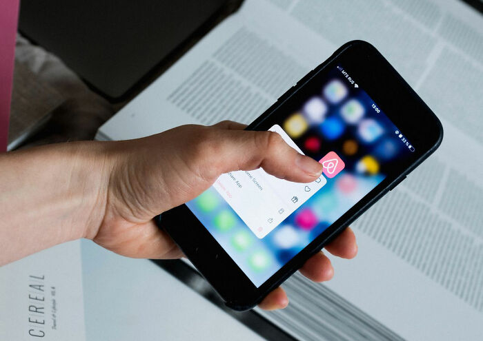 Person tapping an app on a smartphone screen as one of many clever life tricks for digital organization.