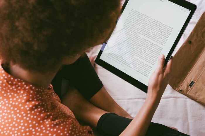A person reading an e-book on a tablet as part of clever life tricks for better learning